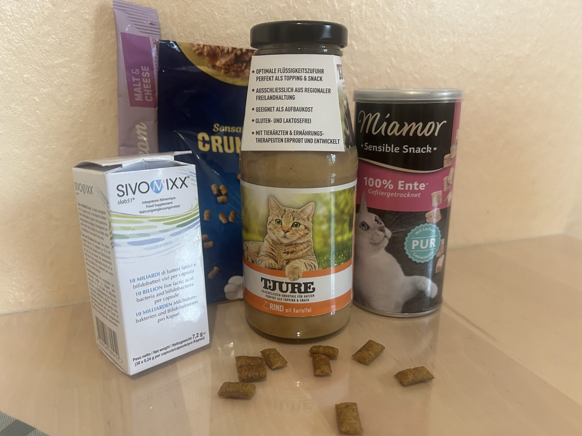 verschiedene Futterzusätze und Snacks für Katzen, darunter Brühe, Probiotika und Leckerli zur Unterstützung beim Päppeln
