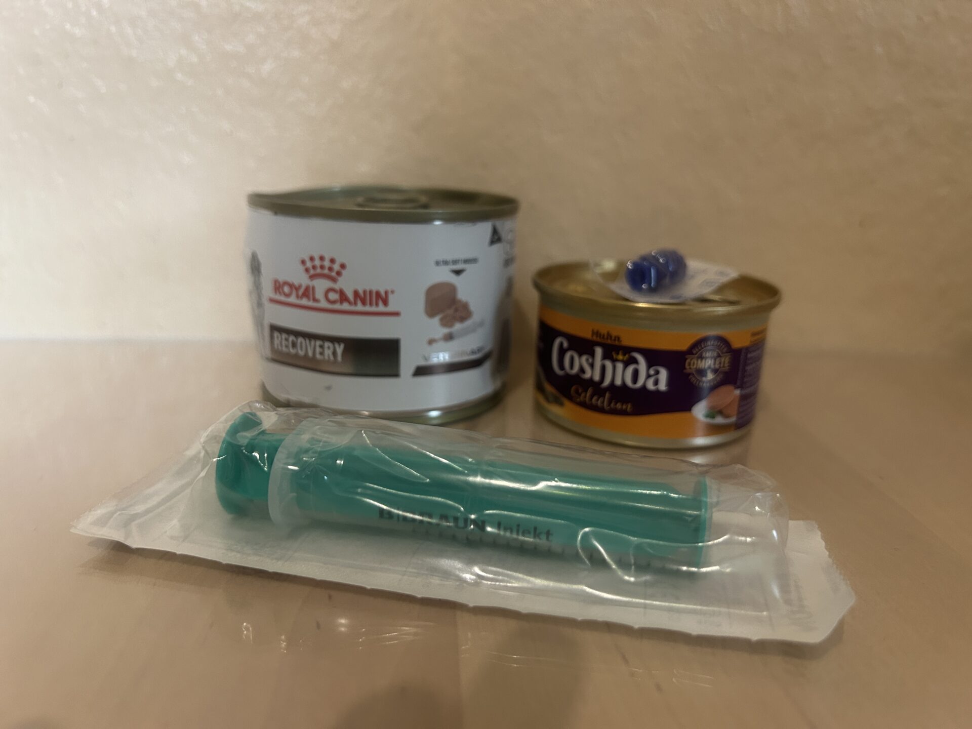 Fütterungsspritze vor Katzennassfutter als Hilfsmittel für die schonende Zwangsfütterung von stark geschwächten Katzen, die gepäppelt werden müssen.